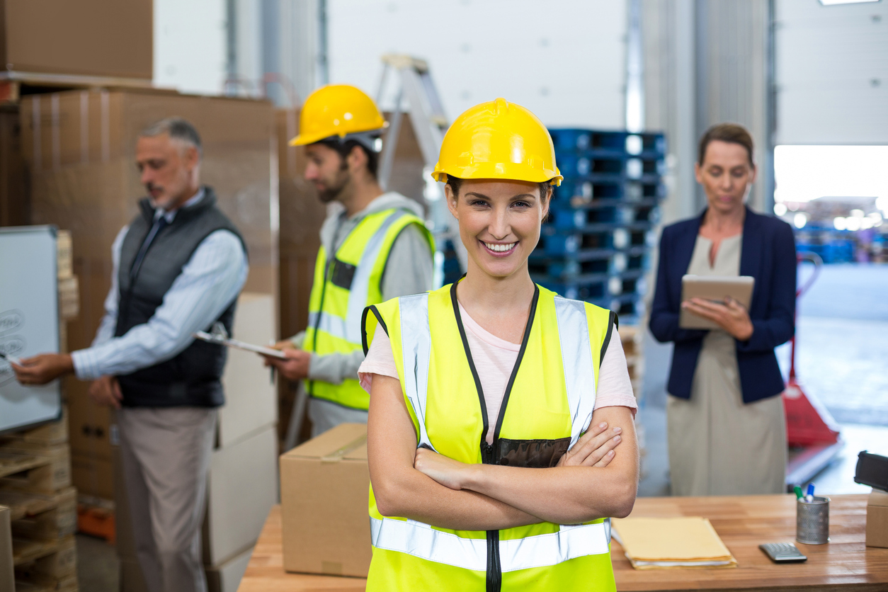 Portrait of female warehouse worker standing with arms crossed in a warehouse